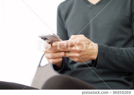 Asian man typing text on his smartphone 86850269