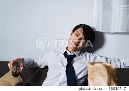 年輕商人在工作結束時喝外賣食品和酒 86850547