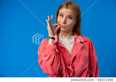 Young pretty woman showing silence gesture over blue background Young pretty woman showing silence gesture over blue background 86851986