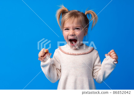 Naughty little girl over the blue background Naughty little girl over the blue background 86852042