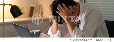 Overwork Concept The male who works at the office tonight holding his head because of getting stressed from work Overwork Concept The male who works at the office tonight holding his head because of getting stressed from work 86852461