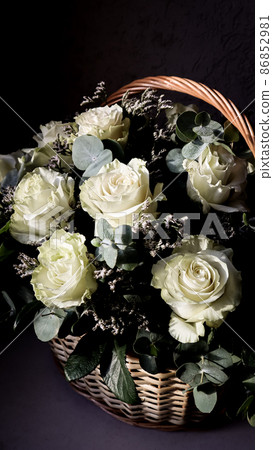 Bouquet of beautiful white roses in a wicker basket on a dark background. Perfect for greeting card Bouquet of beautiful white roses in a wicker basket on a dark background. Perfect for greeting card 86852981