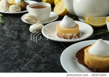 Concept of tasty breakfast with lemon cupcakes and macaroons Concept of tasty breakfast with lemon cupcakes and macaroons 86853884