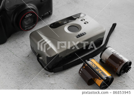Vintage analog camera with film on light background Vintage analog camera with film on light background 86853945