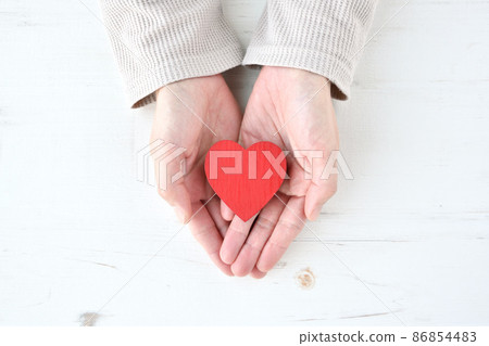 A woman holding a heart-shaped object A woman holding a heart-shaped object 86854483