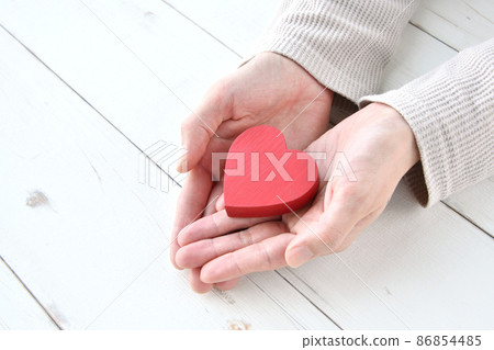 A woman holding a heart-shaped object 86854485