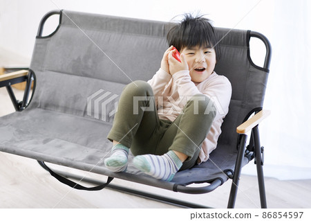 Asian toddler having fun talking on the phone Asian toddler having fun talking on the phone 86854597