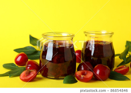 Cherry jam and ingredients on yellow background 86854846