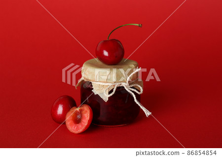 Cherry jam and ingredients on red background Cherry jam and ingredients on red background 86854854