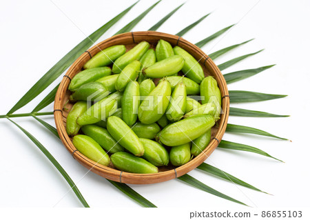 Bilimbi fruit in bamboo basket on white background. 86855103
