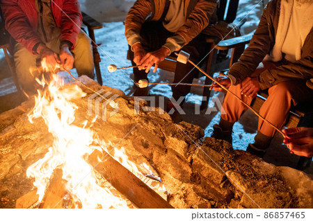 People cooking marshmallows during winter hike People cooking marshmallows during winter hike 86857465