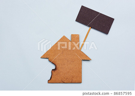 Burned paper house model on blue background. Home insurance concept 86857595