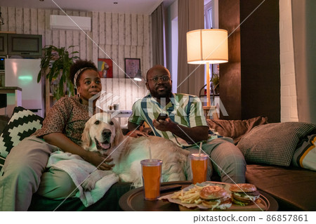 African couple sitting at home with dog 86857861