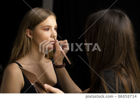 Eyeshadow applying by proffesional make up artist. Makeup for eyes. 86858714