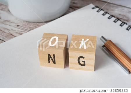 Blocks, pens, notebooks, coffee cups with "OK" and "NG" written on them 86859883