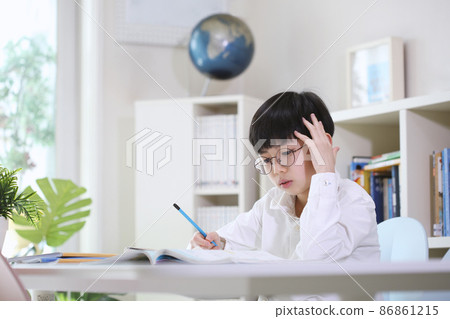 Boy thinking carefully, concentrating and studying hard at his desk Boy thinking carefully, concentrating and studying hard at his desk 86861215