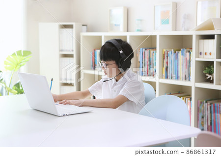 戴著無線耳機並在筆記本電腦上上網課的年輕學生 86861317