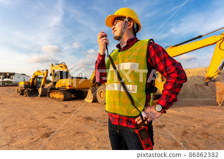 asian technician civil engineer talk with team by walkie talkie and point at inspection survey point for transport construction work project with excavator on engineering site background asian technician civil engineer talk with team by walkie talkie and point at inspection survey point for transport construction work project with excavator on engineering site background 86862382