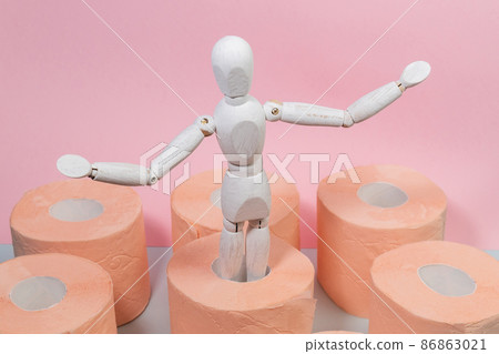Toilet paper orange color with wooden maneken. Hygiene concept. Copy space 86863021