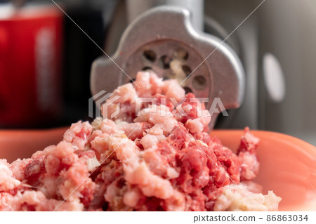Meat grinder and mince comes out of it. Minced meat, meat delicacies, fresh home food. Homemade food Meat grinder and mince comes out of it. Minced meat, meat delicacies, fresh home food. Homemade food 86863034