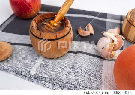 Fermented garlic cloves honey, a rich source of probiotics, white background Fermented garlic cloves honey, a rich source of probiotics, white background 86863035