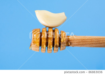 Fermented garlic honey close up on a blue background. Copy Space Fermented garlic honey close up on a blue background. Copy Space 86863036