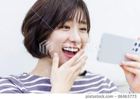 Female using a smartphone at home 86863773