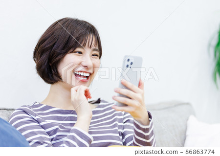 Female using a smartphone at home 86863774