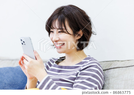 Female using a smartphone at home 86863775