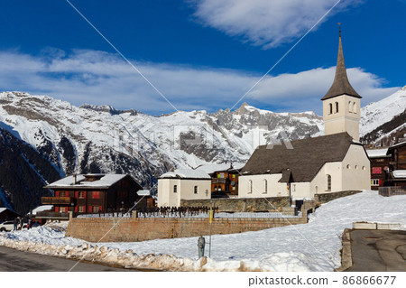 Winter view of Swiss township of Bellwald with parish church Winter view of Swiss township of Bellwald with parish church 86866677