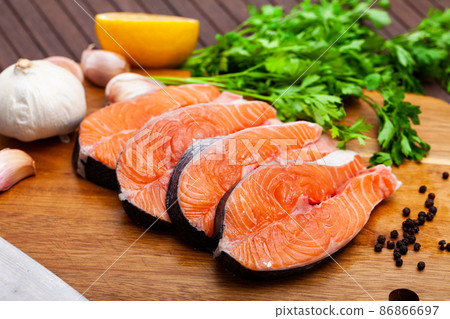 Raw salmon steaks with lemon, parsley, garlic Raw salmon steaks with lemon, parsley, garlic 86866697
