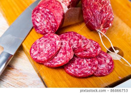 Sliced Iberian dry cured pork sausage salchichon on wooden background 86866753