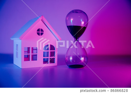 Miniature wooden house and hourglass. Mortgage and loan concept Miniature wooden house and hourglass. Mortgage and loan concept 86866828