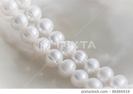 Nature white string of pearls on marble background in soft focus, with highlights Nature white string of pearls on marble background in soft focus, with highlights 86866916