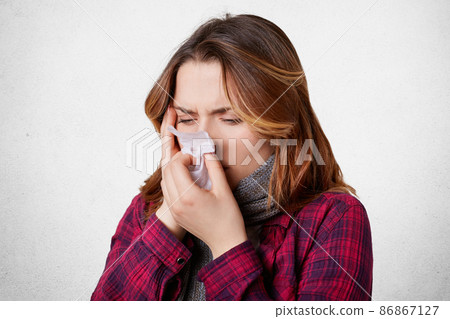 Sick desperate woman has flu, running nose, blows nose in handkerchief, has terrible headache, caught cold after long walk outside during frozy cold weather. Upset female suffers from pneumonia Sick desperate woman has flu, running nose, blows nose in handkerchief, has terrible headache, caught cold after long walk outside during frozy cold weather. Upset female suffers from pneumonia 86867127
