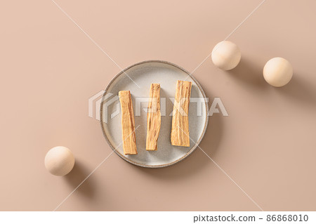 Sticks of Palo Santo tree on a beige background. Minimal style. Ritual cleansing, meditation, aromatherapy. Sticks of Palo Santo tree on a beige background. Minimal style. Ritual cleansing, meditation, aromatherapy. 86868010