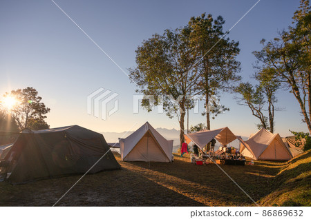 Tents camping in campsite on hill with sunrise over mountain at national park Tents camping in campsite on hill with sunrise over mountain at national park 86869632