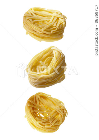 Uncooked fettuccine, noodles pasta nest set isolated on white background, levitating food Uncooked fettuccine, noodles pasta nest set isolated on white background, levitating food 86869717
