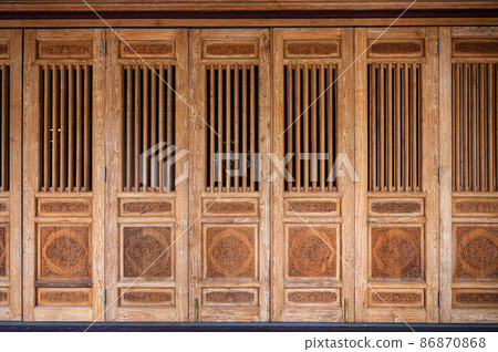 Aged wooden door with carved dragon in chinese temple 86870868