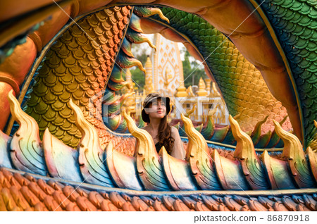 Happy asian woman smiling in colorful serpent statue at Wat Phra That Nong Bua temple 86870918