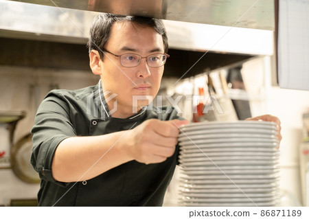 Male staff preparing food at a restaurant 86871189