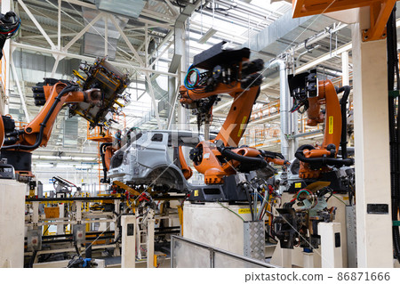Photo of automobile production line. Modern car assembly plant. Auto industry. Interior of a high Photo of automobile production line. Modern car assembly plant. Auto industry. Interior of a high 86871666