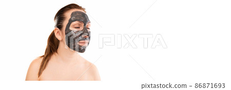 portrait of a middle-aged woman in a black cosmetic mask on her face against a white wall 86871693