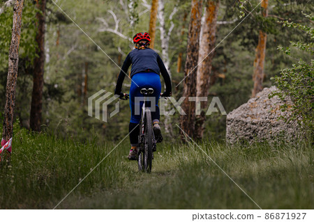 back woman riding mountain bike on forest trail 86871927