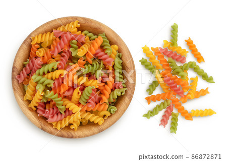 raw Fusilli colored pasta in wooden bowl isolated on white background with clipping path and full depth of field. Top view. Flat lay raw Fusilli colored pasta in wooden bowl isolated on white background with clipping path and full depth of field. Top view. Flat lay 86872871