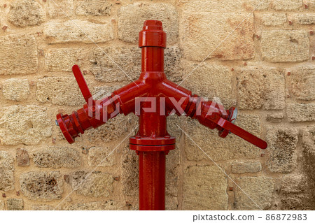 fire hydrant near vintage stone wall 86872983