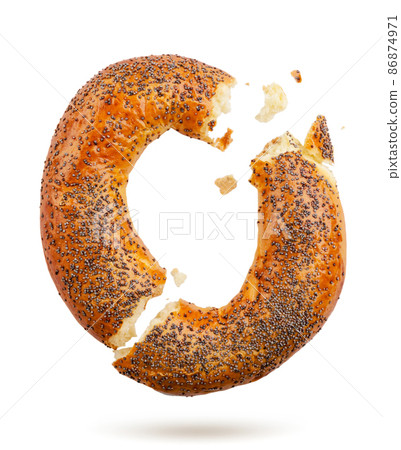 Bagel with poppy seeds broken falls on a white background. Isolated 86874971