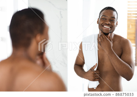 Self Care Concept. Shirtless Black Handsome Man Looking At Mirror In Bathroom Self Care Concept. Shirtless Black Handsome Man Looking At Mirror In Bathroom 86875033
