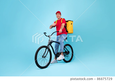 Cheerful Male Courier With Bike Gesturing Thumbs Up, Blue Background 86875729