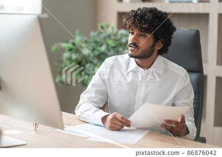 Young indian businessman working in the office Young indian businessman working in the office 86876042